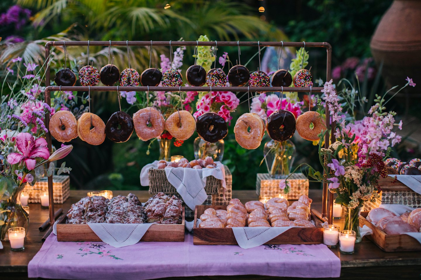Dessert display with donuts and pastries on a wooden table.