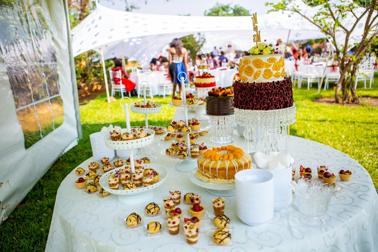 An outdoor table filled with various desserts for a celebration.